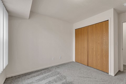 A room with a wooden wardrobe and a carpeted floor.