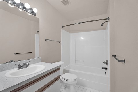 A white bathroom with a toilet, sink, and shower.