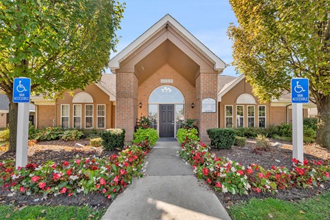 A building with a sign that says "Accessible" is surrounded by flowers.