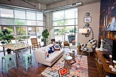 a living room with a couch and a table in front of large windows
