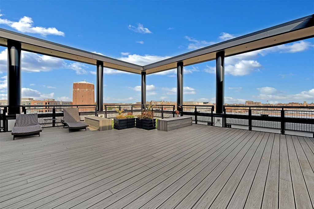 a balcony with a view of a city and a blue sky