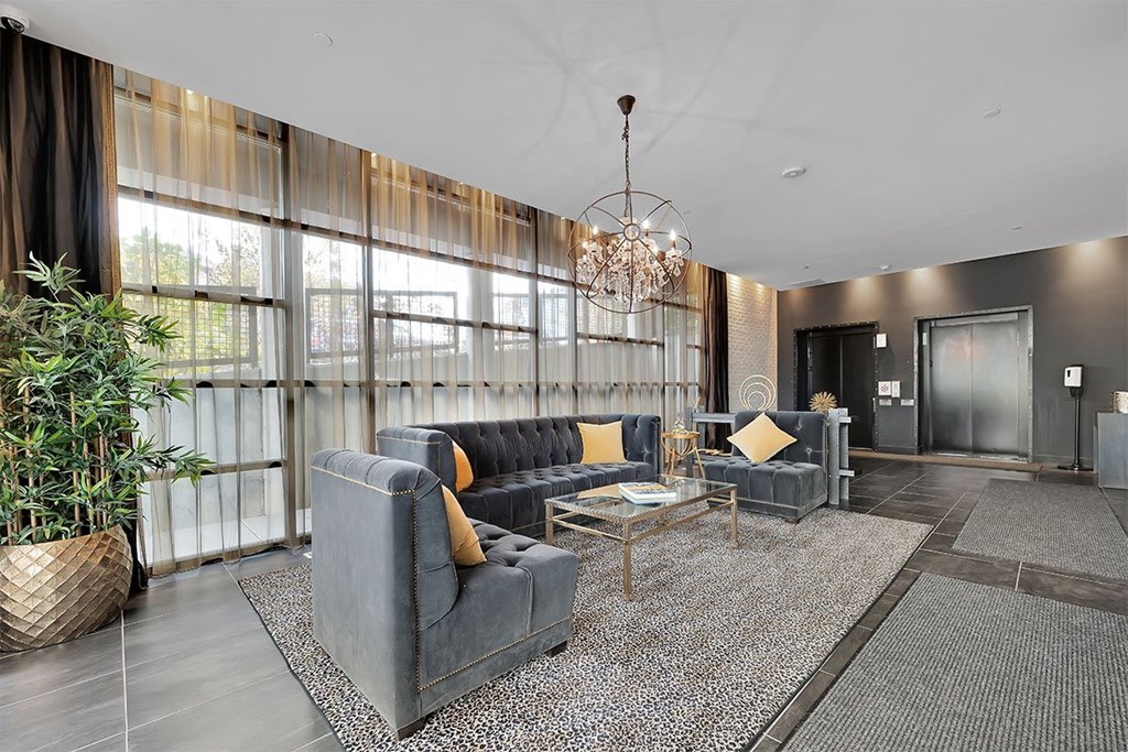a lobby with couches and chairs and a chandelier
