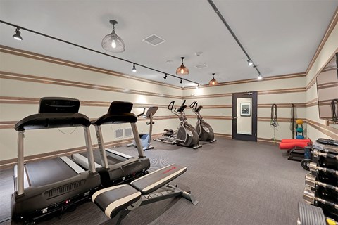 a gym with various machines and chairs in it