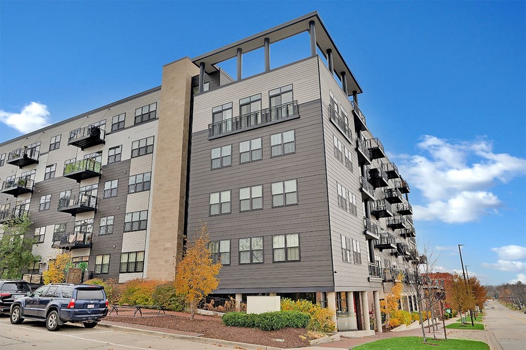 a tall apartment building with cars parked in front of it