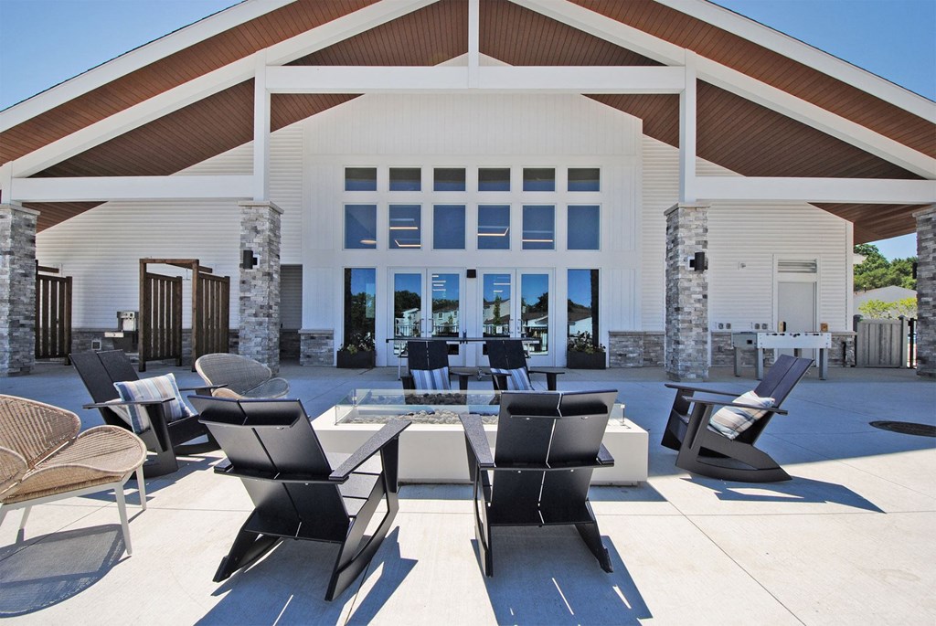 a patio with chairs and a table in front of a building