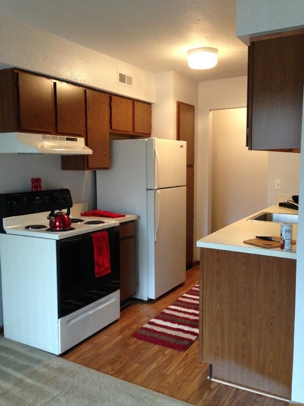 A kitchen with a white stove and black oven.