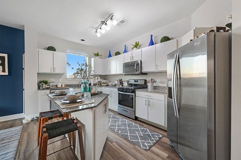 A kitchen with white cabinets and a stainless steel refrigerator.