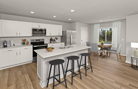 A modern kitchen with white cabinets and a large island.