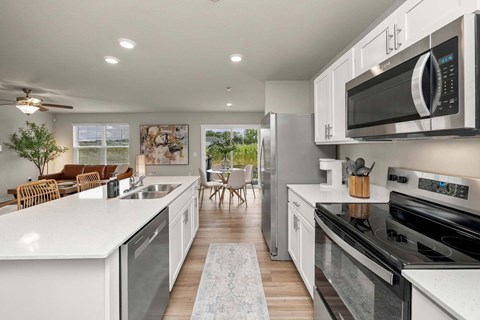 A modern kitchen with white cabinets and stainless steel appliances.