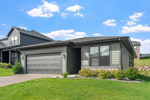 A house with a grey garage door and a grey roof.