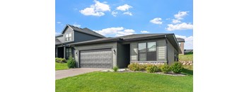 A house with a grey garage door and a grey roof.
