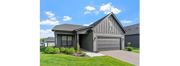 A house with a grey garage door and a grey roof.
