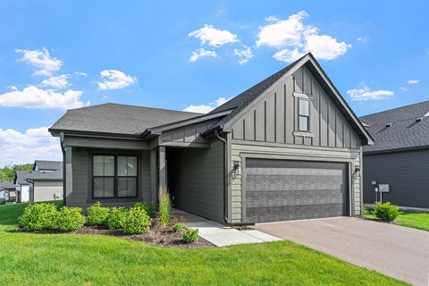 A house with a grey garage door and a grey roof.