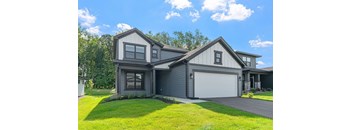 A modern house with a grey exterior and a white garage door.