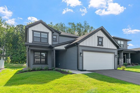 A modern house with a grey exterior and a white garage door.