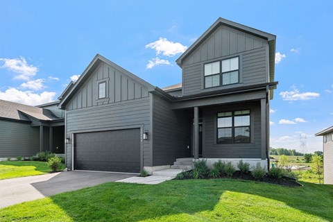 A modern house with a grey exterior and a large garage door.
