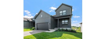 A modern house with a grey exterior and a large garage door.