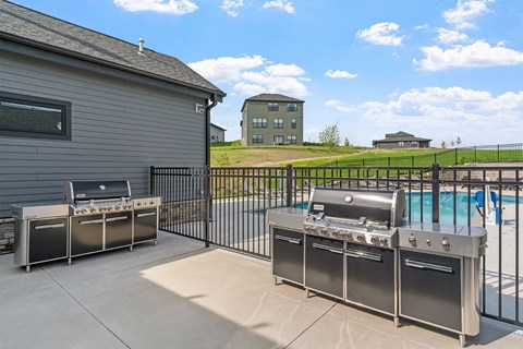 A backyard with a grill and a pool.