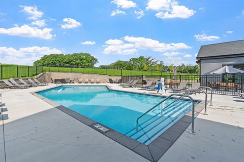 A large outdoor swimming pool with a metal railing around it.
