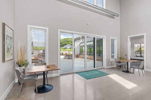 A dining room with a table and chairs and a view of the backyard through the glass doors.