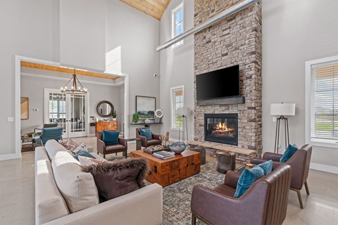 A living room with a stone fireplace and a large couch.