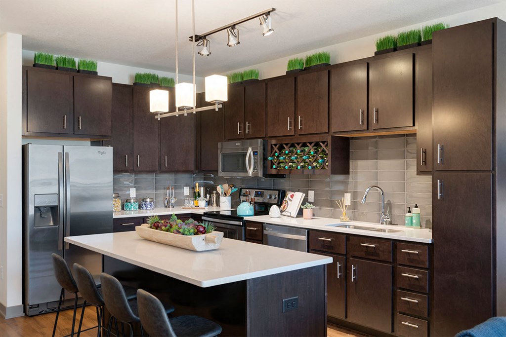 a kitchen with a large island and stainless steel appliances