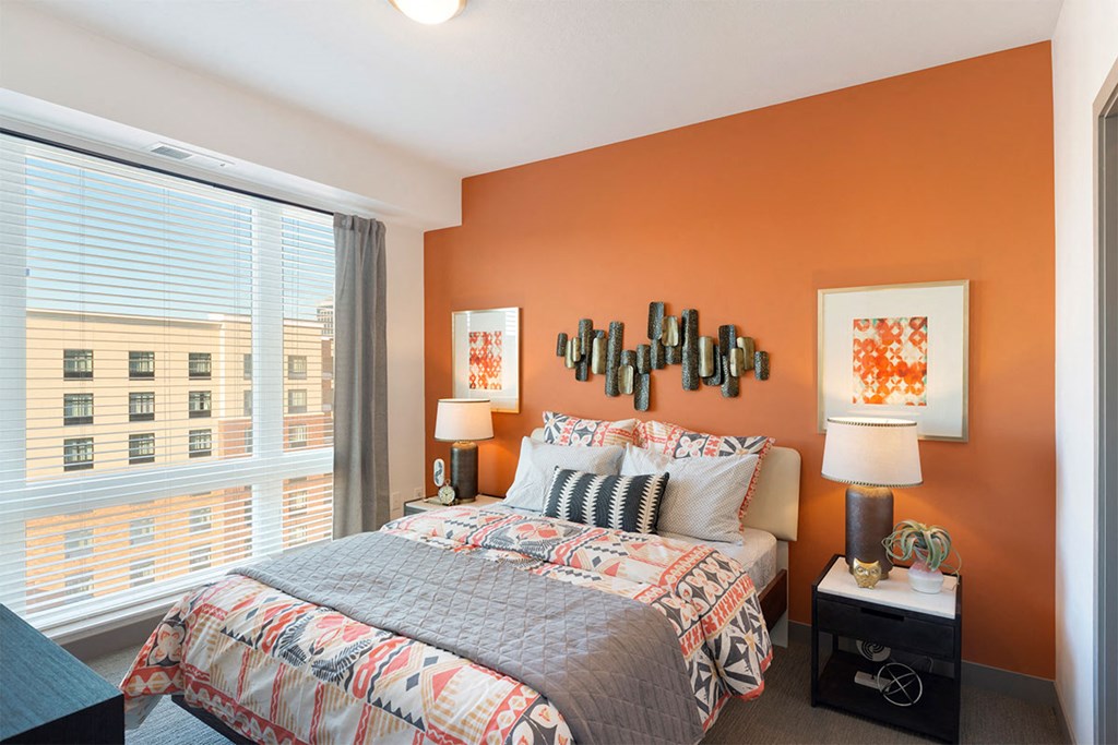 a bedroom with a bed and a large window