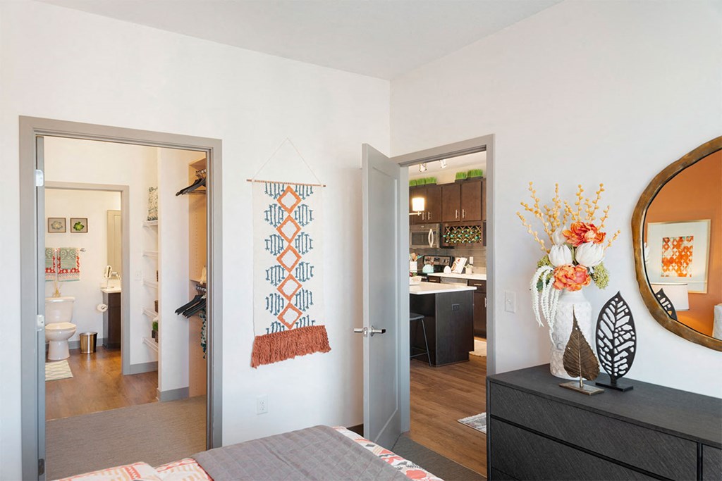 a bedroom with a bed and a mirror and a living room