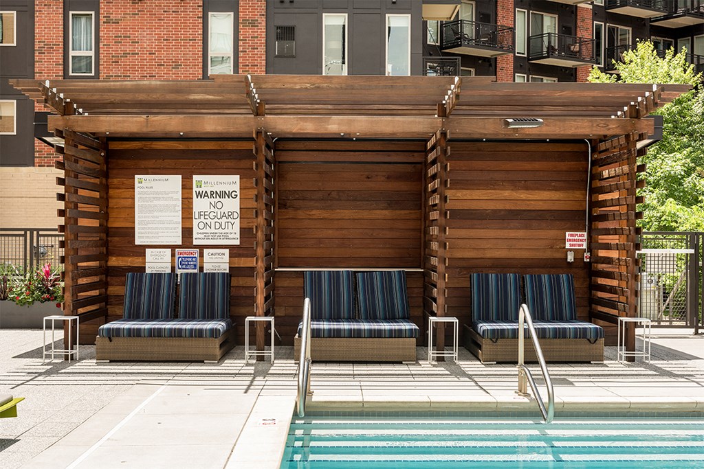 a building with a pool and chairs in front of it