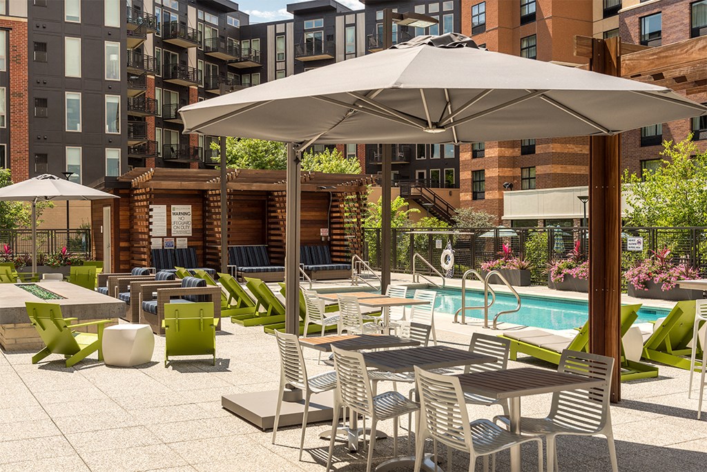 a rendering of a pool and patio with tables and umbrellas