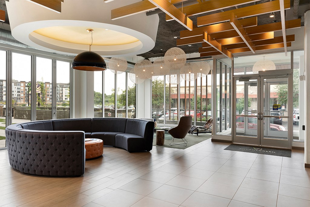 a lobby of a building with couches and glass doors