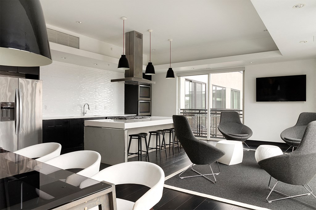 an open kitchen and living room with chairs and a bar