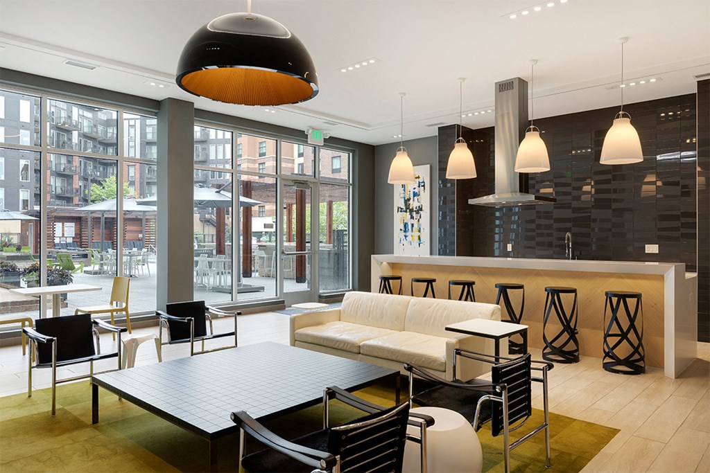 a lounge area with a white couch and tables and chairs