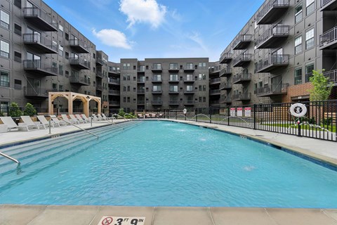 A swimming pool in front of apartment buildings.