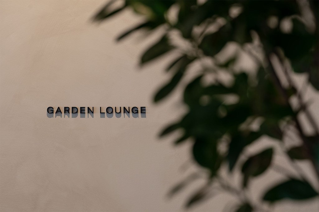A blurry image of a plant with the words "Garden Lounge" written on it.