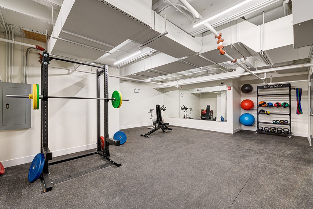 a workout room with weights and other exercise equipment in a large space