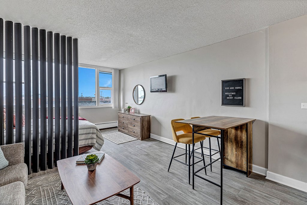 a living room with a desk and a bed