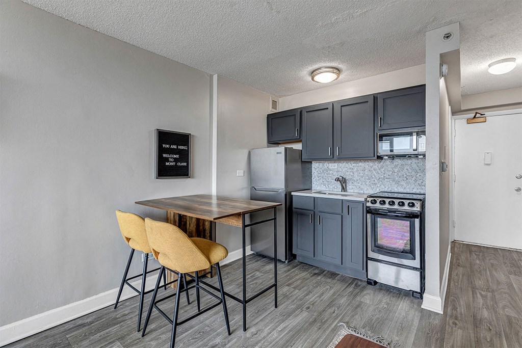 a kitchen with a table and chairs and a refrigerator