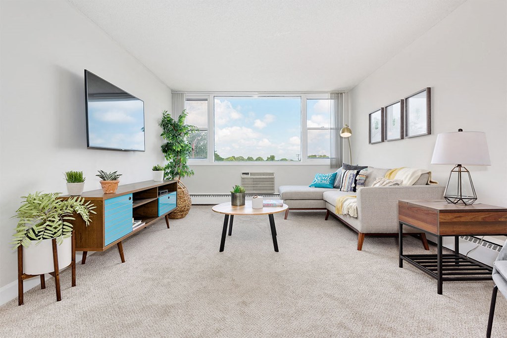 a living room with a couch and a tv and a window