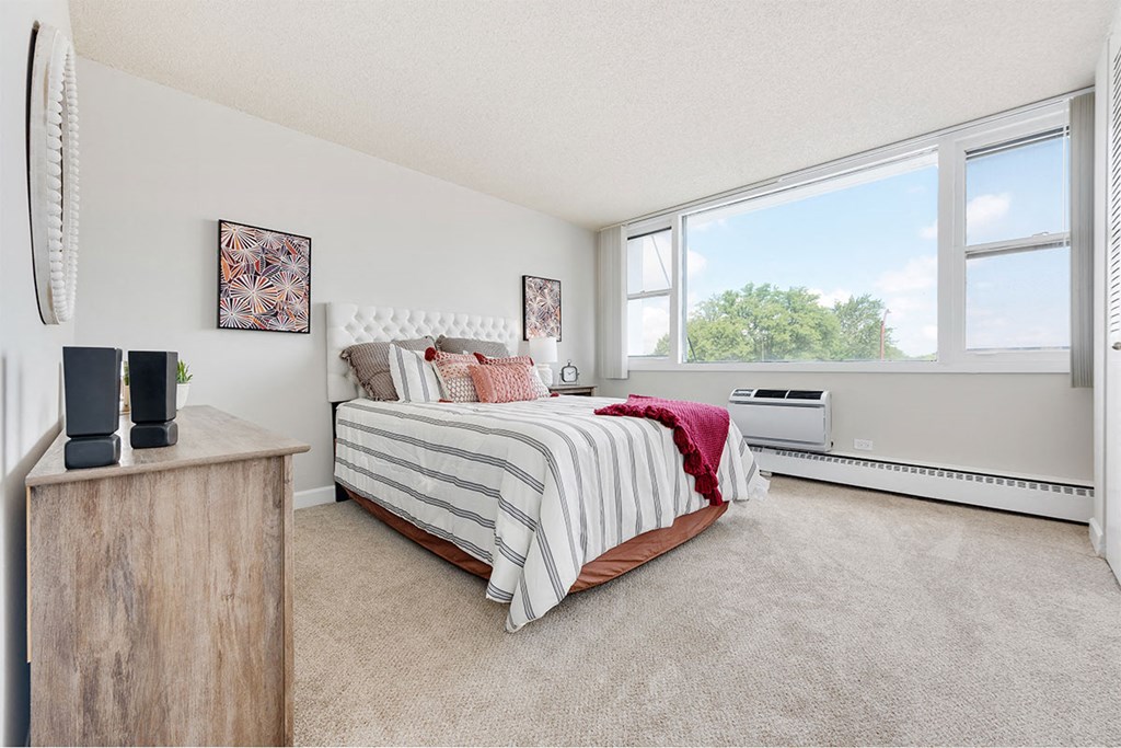 a bedroom with a bed and a large window