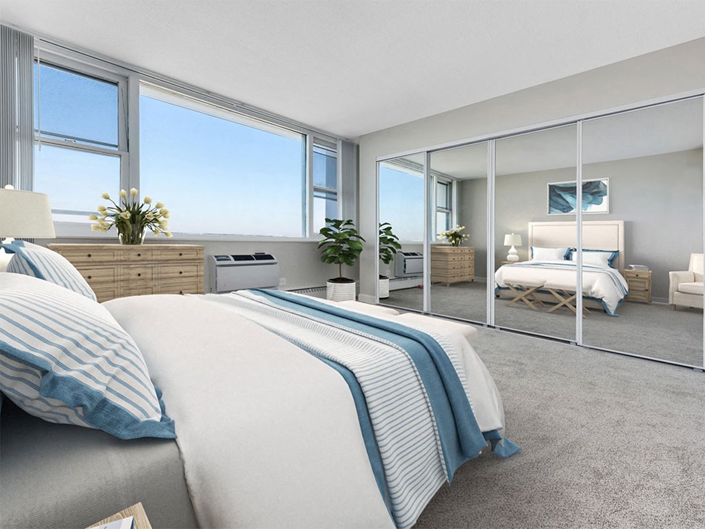 a bedroom with large windows and a bed with blue and white bedding