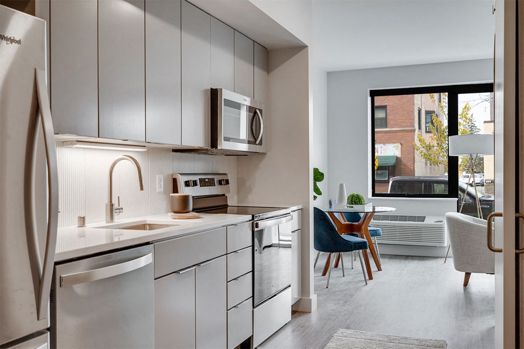 A modern kitchen with a white fridge, microwave, and stove top oven.