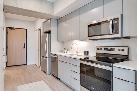 A modern kitchen with a refrigerator, oven, and microwave.