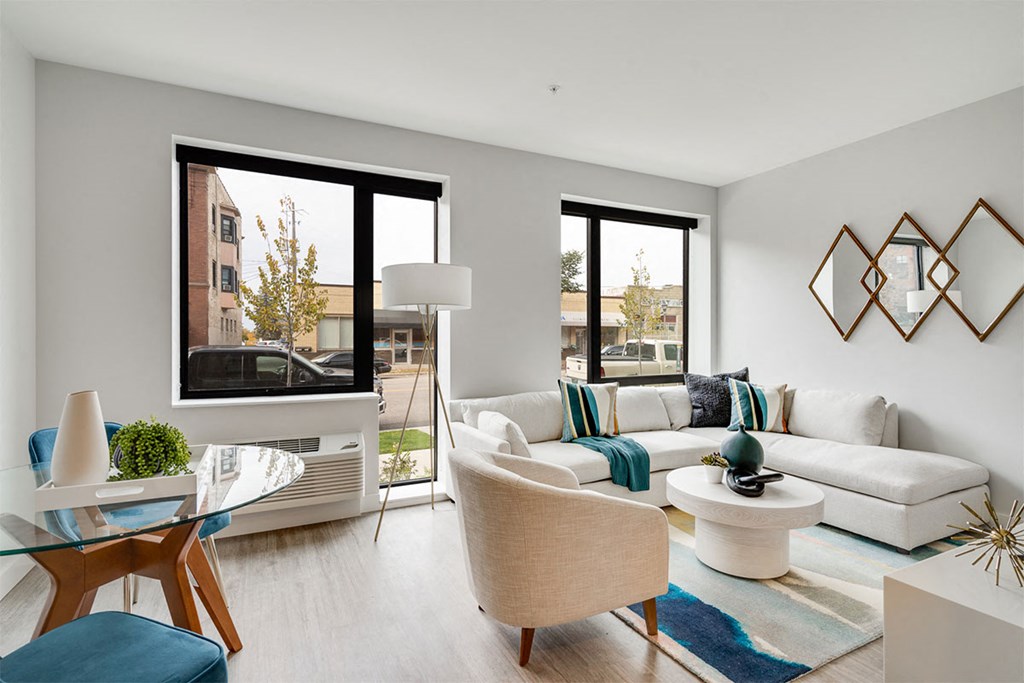 A modern living room with a glass table and white couch.
