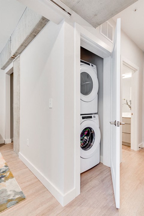 A white washing machine is in a white doorway.