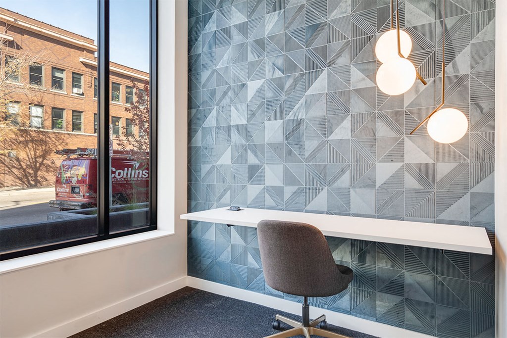 A chair is in front of a window with a view of a building with the sign "Collins".