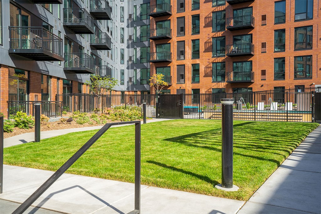 A modern apartment complex with a green lawn in front.