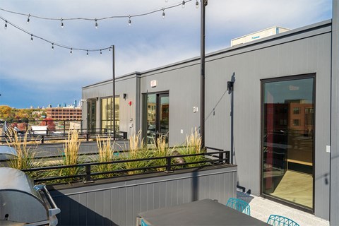 A grey building with a balcony and plants.