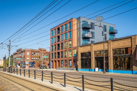 A street view of a city with buildings and a fence.