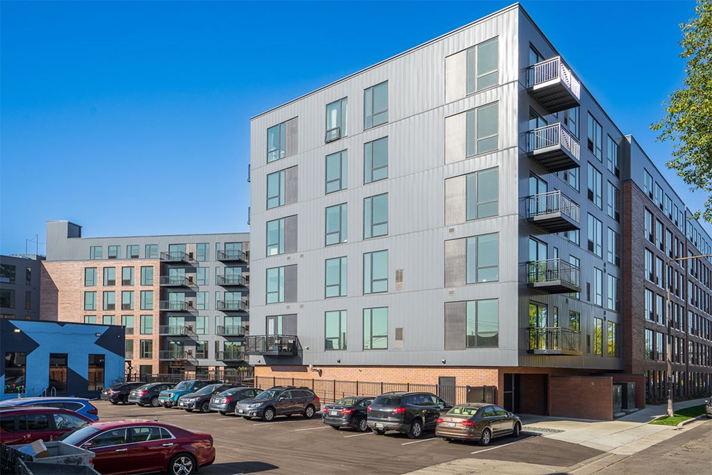 A modern building with a parking lot in front.